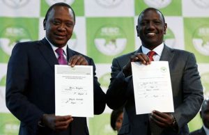 Uhuru Kenyatta e il suo vice William Ruto mostrano i certificati che li confermano nelle rispettive cariche